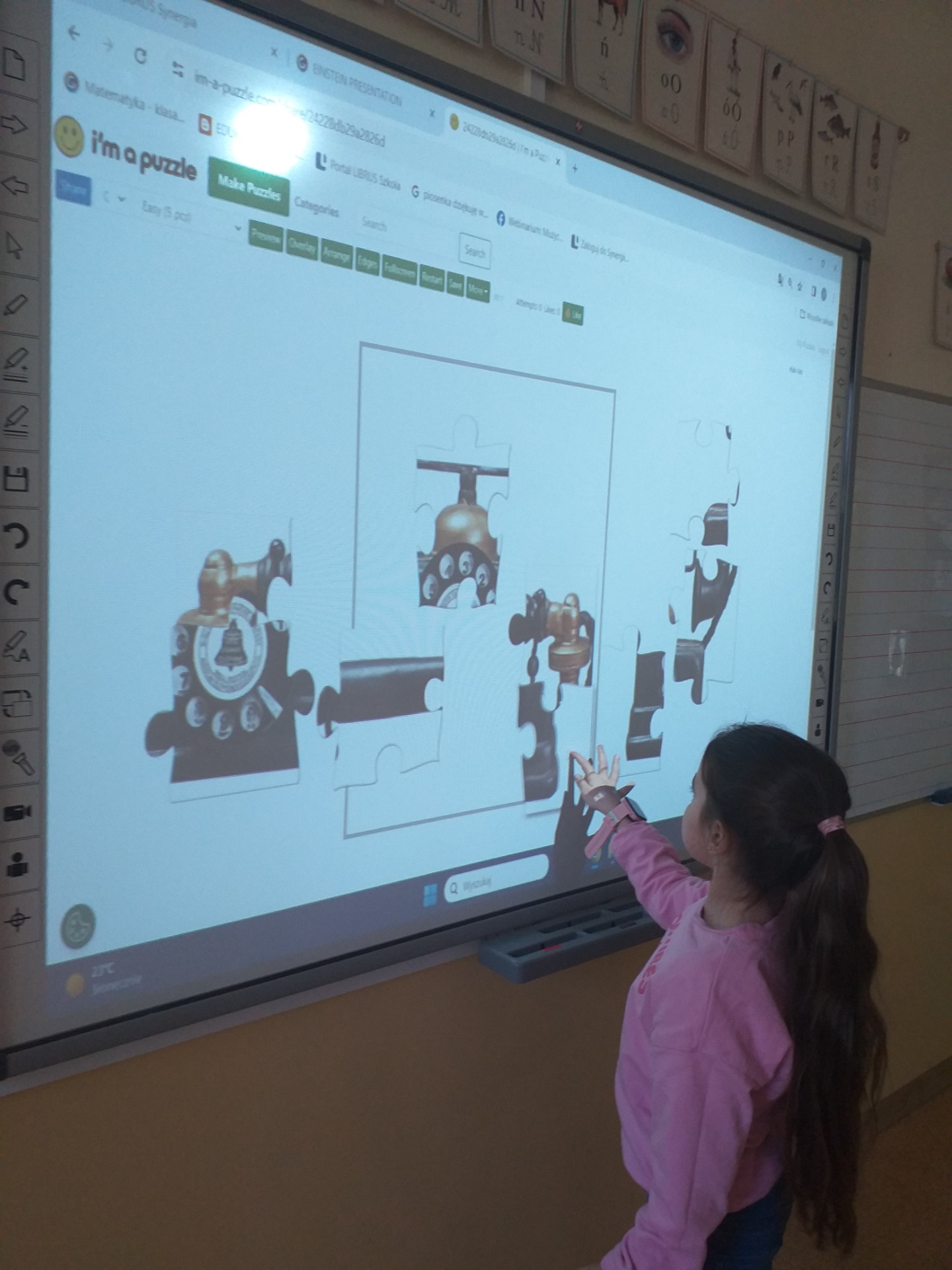 Uczennica układa puzzle interaktywne.