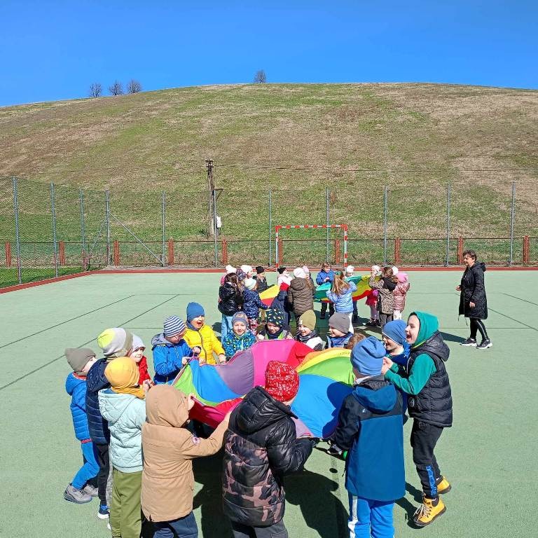 Uczniowie oddziałów przedszkolnych podczas zabawy na boisku szkolnym
