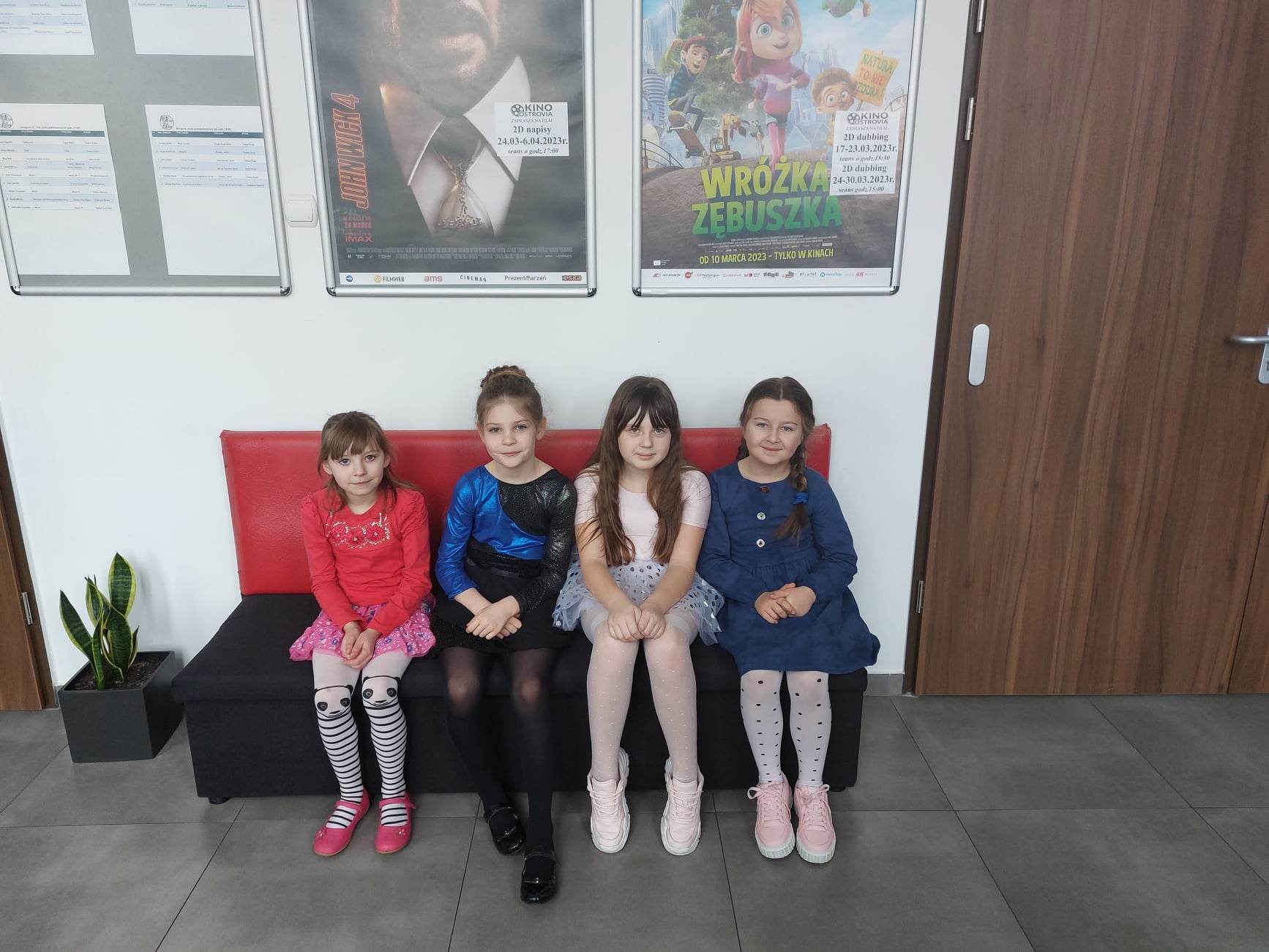Cztery dziewczynki siedzą na kanapie w oczekiwaniu na występy konkursowe