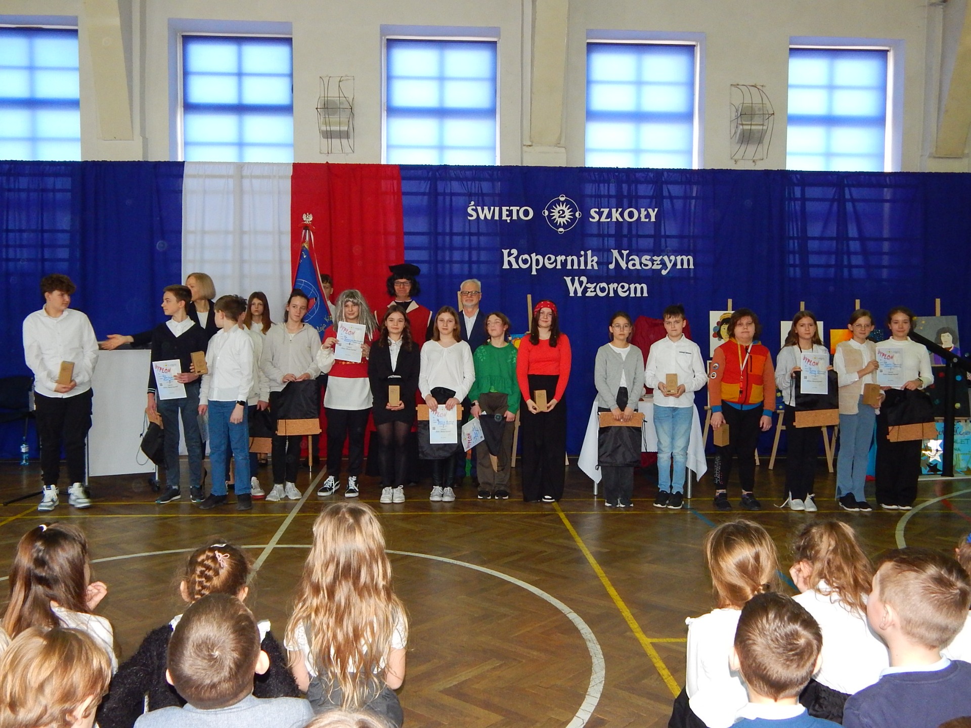 Uczniowie, nauczyciele, rodzice, pracownicy, Dyrekcja i zaproszeni goście podczas Święta Szkoły z okazji 551 rocznicy urodzin patrona - Mikołaja Kopernika