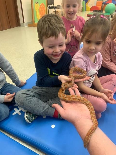dziecko z wężem na rękach