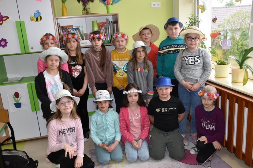 Grupa uczniów w kapeluszach i wiankach na głowie