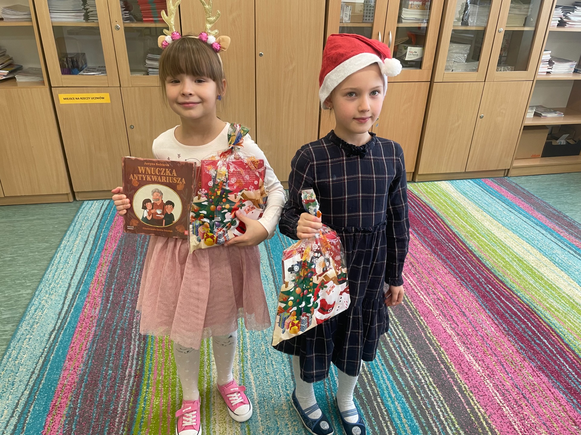 dwie dziewczynki trzymające prezenty