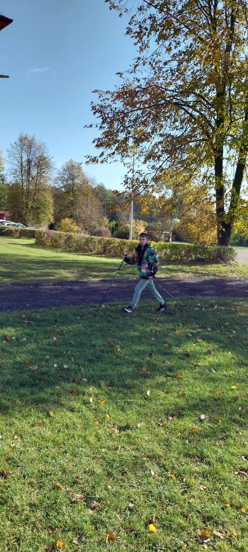 Uczniowie uprawiają nordic walking na szkolnym boisku